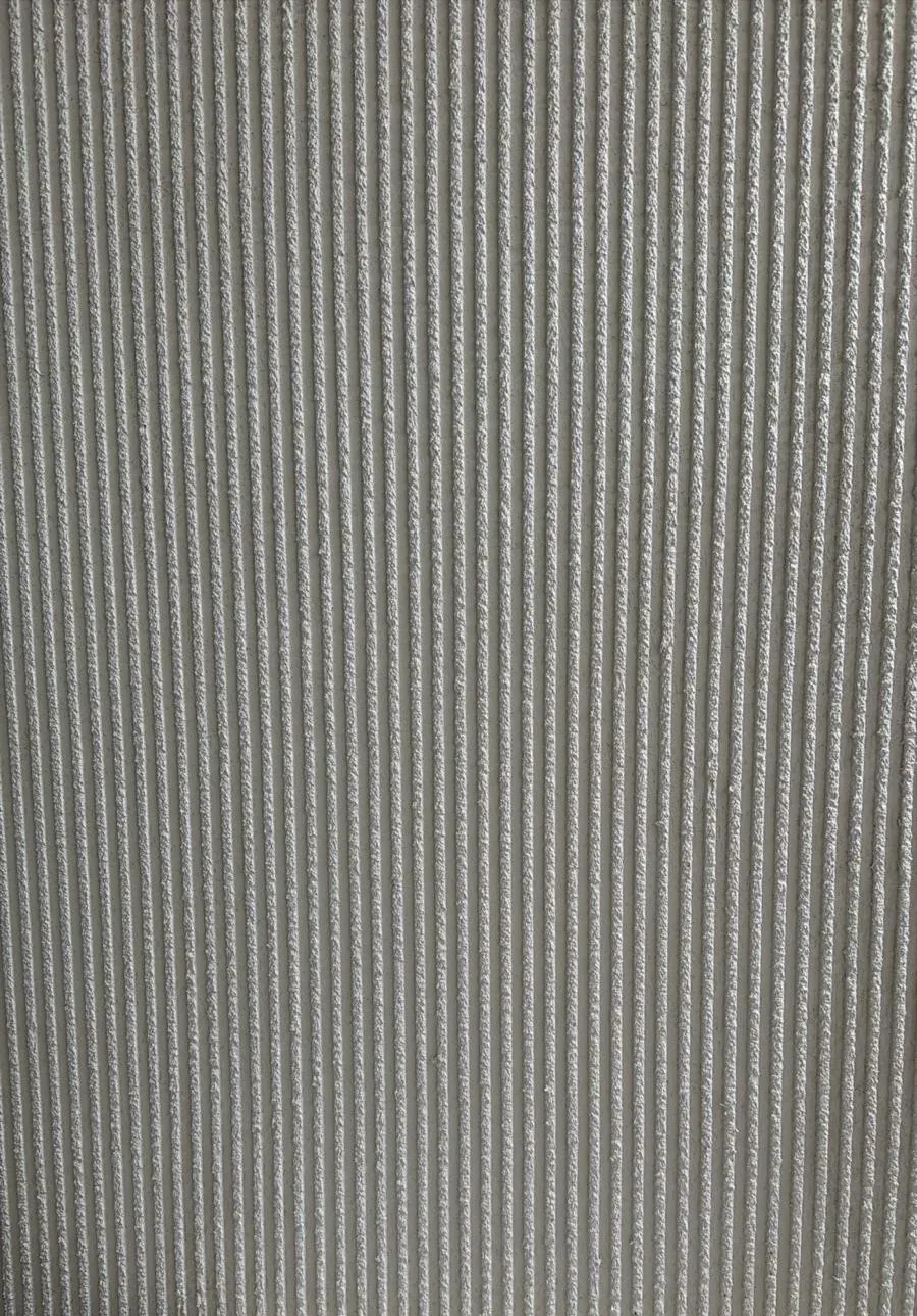 Gros plan : crépi cannelé fraîchement tiré, stries verticales régulières